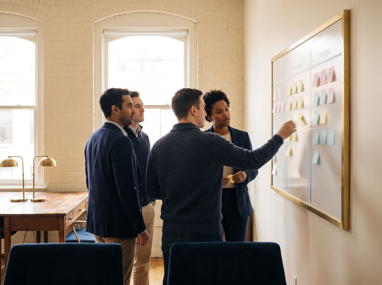 A team arranges sticky notes on a planning board